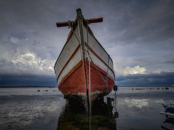 View of fishing boat on beach against sky