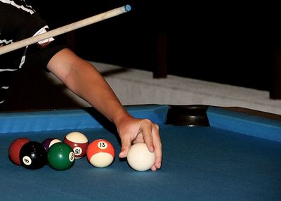 Cropped image of person playing pool