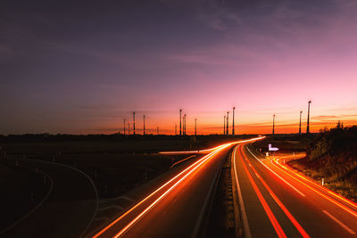 Light trails on highway at sunset