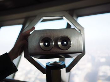 Close-up of hand holding camera against sky