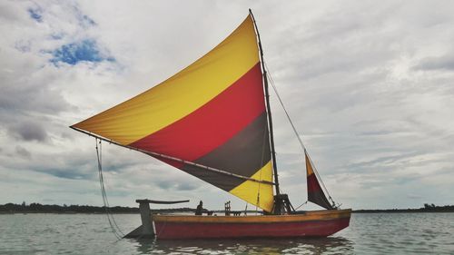 Sailboat sailing in sea against sky