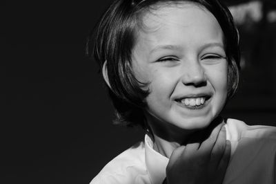 Portrait of smiling girl against black background