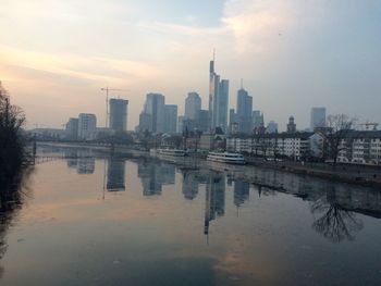 Reflection of city in water against sky