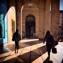 Rear view of woman standing in front of building