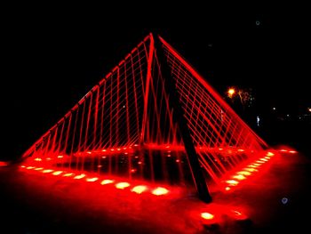 Low angle view of illuminated bridge at night
