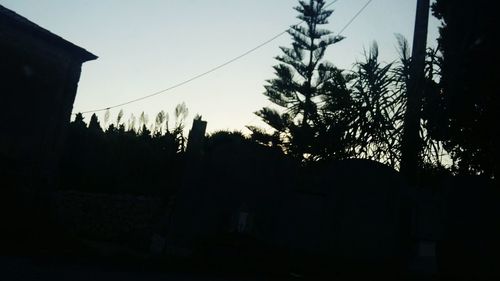 Silhouette trees against sky at sunset