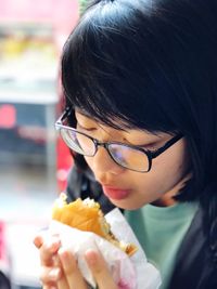 Close-up of girl eating burger in restaurant