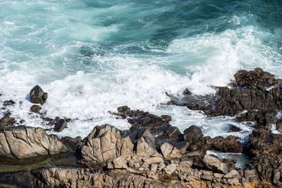 Ocean waves breaking on the rocks on the beach. 
