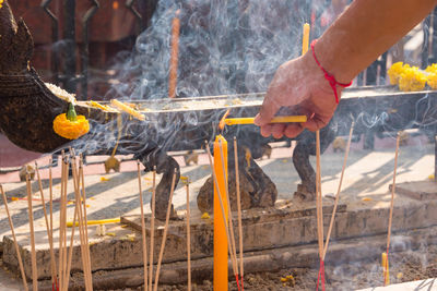 Close-up of man preparing food on barbecue grill