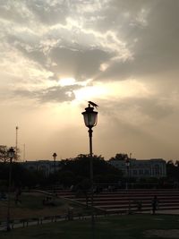 Street lights against sky at sunset