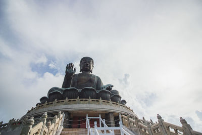 Low angle view of statue of building against cloudy sky