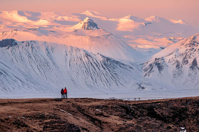 Rear view of person on snowcapped mountain against sky