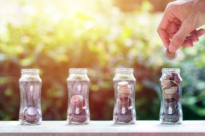 Close-up of hand holding glass jar against blurred background