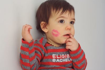 Close-up of baby with lipstick kiss on cheek