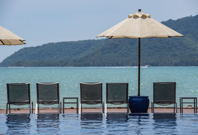 Sun loungers and parasol by the pool at holiday resort in phuket