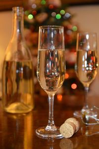 Close-up of wine served against christmas tree on table