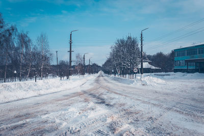 Snow covered road against sky