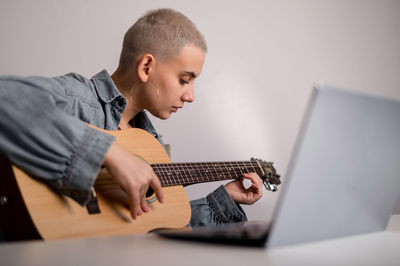 Full length of boy playing guitar