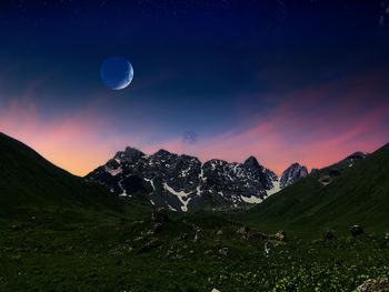 Scenic view of snowcapped mountains against sky at night