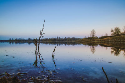 Scenic view of lake against clear blue sky