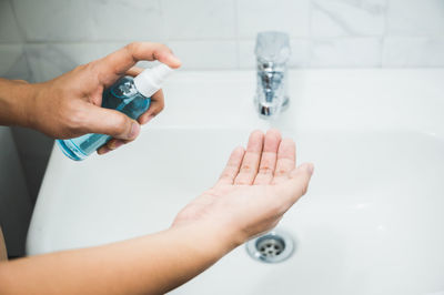 Close-up of hand holding hands in bathroom at home