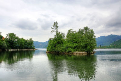 Scenic view of lake by trees against sky