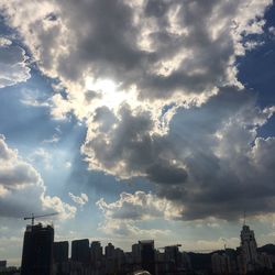 Modern cityscape against cloudy sky