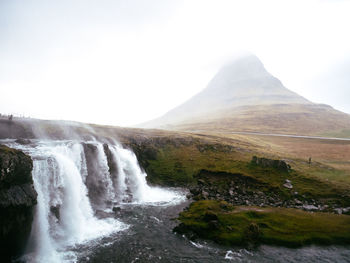 Scenic view of waterfall against mountain