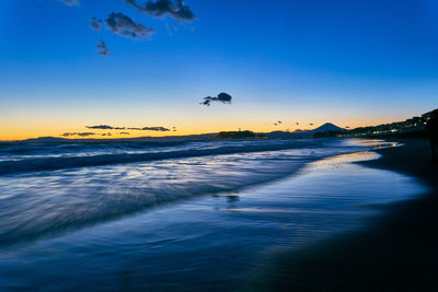 Scenic view of beach against sky during sunset