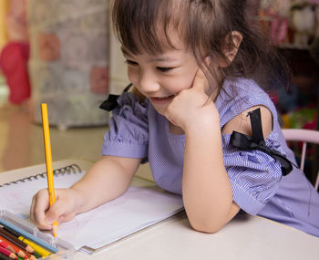 Cute girl sitting on table