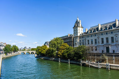 Arch bridge over river against buildings in city