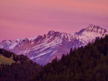 Scenic view of snowcapped mountains against sky during sunset