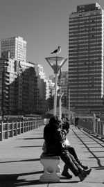 Girl and woman in city against clear sky