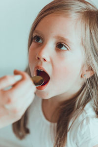 Cropped hand of mother feeding daughter at home