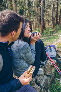 Young man using mobile phone in forest