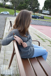 Full length of woman sitting on bench