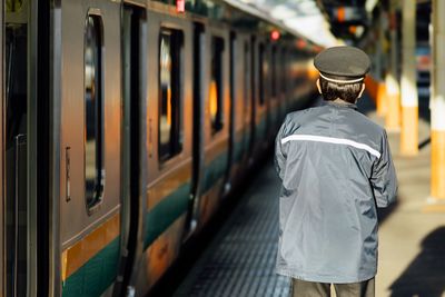 Rear view of man on train at railroad station