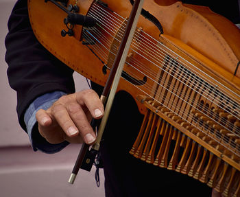 Midsection of man playing musical instrument