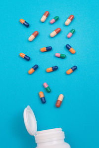 High angle view of colored pencils over blue background