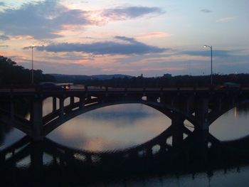 Bridge over river against cloudy sky