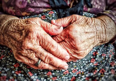 Midsection of senior woman with hands on stomach