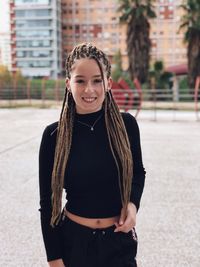 Portrait of smiling young woman standing outdoors