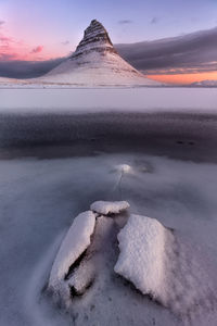 Scenic view of frozen lake against sky during sunset