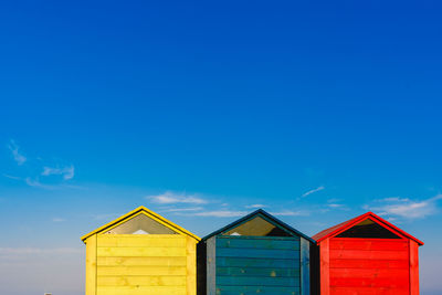 Multi colored beach huts against sky
