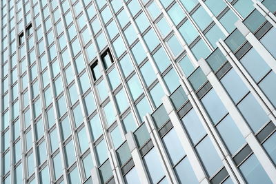 Low angle view of glass building against sky