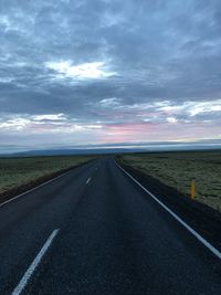 Empty road against cloudy sky