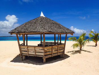 Lifeguard hut on beach against blue sky