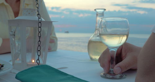 Close-up of beer glass on table against sea