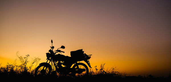 Silhouette plants on field against sky during sunset