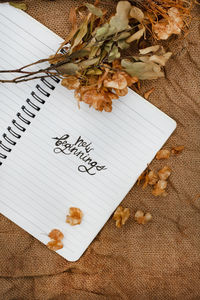 Notebook with new beginnings in handwriting on rustic surface